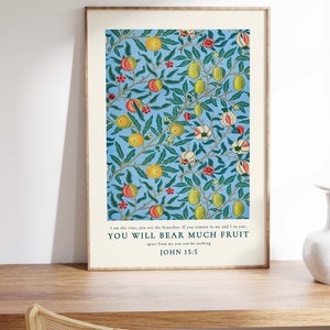 May include: A framed print with a blue background and a repeating pattern of green leaves, yellow lemons, and pink and red flowers. The print features a quote from the Bible, John 15:5, which reads: "I am the vine, you are the branches. If you remain in me and I in you, YOU WILL BEAR MUCH FRUIT apart from me you can do nothing."