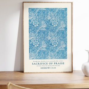 May include: A framed print with a blue floral pattern and a white background. The print features a quote from Hebrews 13:15, "Through Jesus, therefore, let us continually offer to God a sacrifice of praise - the fruit of lips that openly profess His name."