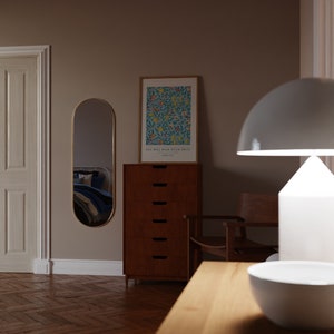 May include: A wooden dresser with six drawers, a white lamp with a white shade, a chair, and a framed print with a floral design and the text "You will bear much fruit" John 15:2. The dresser is in a room with a wooden floor and a white door.