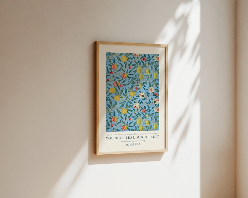 May include: A framed print with a blue background and a repeating pattern of green leaves, yellow lemons, and red and white flowers. The text "YOU WILL BEAR MUCH FRUIT" is printed below the image, with "JOHN 15:5" printed below the text.