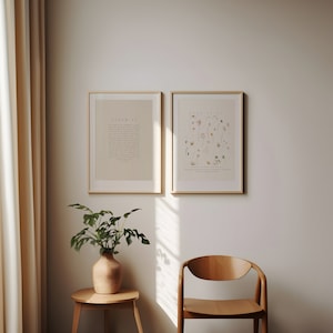 May include: Two framed prints on a white wall. The print on the left has the text "PSALM 23" and the print on the right has the text "LUKE 12:27". A potted plant sits on a small wooden table in the corner of the room.