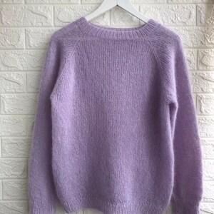 May include: A soft, light purple sweater with long sleeves and a round neckline.