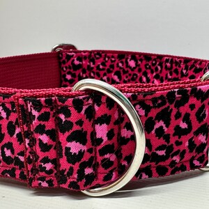May include: A pink and black leopard print dog collar with silver hardware.