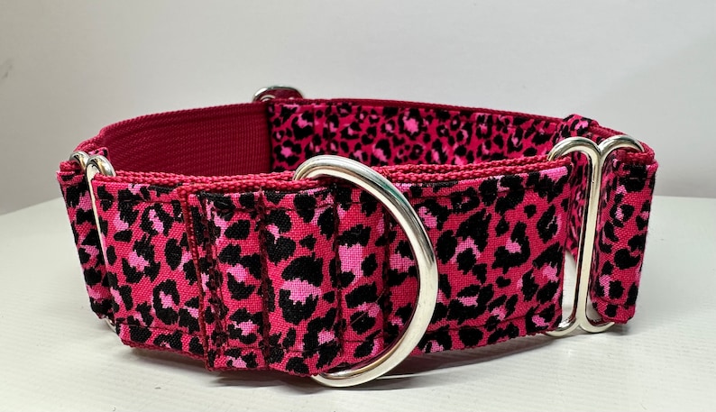 May include: A pink and black leopard print dog collar with silver hardware.