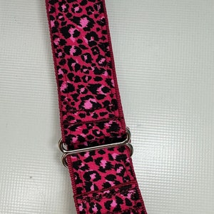 May include: A pink and black leopard print dog collar with silver hardware.