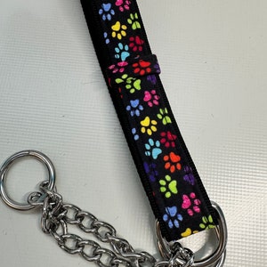 May include: A black dog collar with a rainbow paw print pattern and a silver chain.