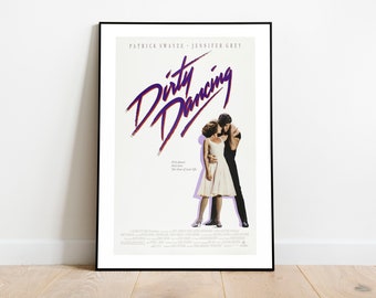 May include: A framed movie poster for "Dirty Dancing" featuring Patrick Swayze and Jennifer Grey. The title is in a purple script font. The poster shows the couple embracing, with the tagline "First love. The time of your life."