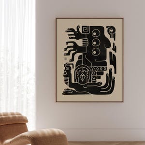 Op de afbeelding: Een ingelijste kunstdruk met een abstract zwart en beige ontwerp. Het kunstwerk toont een gestileerde figuur met meerdere armen en geometrische vormen. De print zit in een bruine lijst en hangt aan een witte muur.