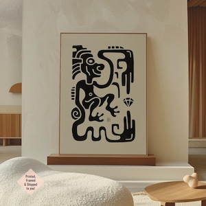 Op de afbeelding: Ingelijst kunstwerk met een zwart-wit abstract ontwerp van een figuur, diamant en hand. Het kunstwerk wordt tentoongesteld op een houten standaard. De tekst linksonder luidt "Printed, Framed & Shipped to you!"