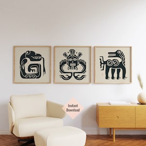 May include: Three black and white prints of stylised animal and human figures in a geometric style. The prints are framed in natural wood frames and hung on a white wall.