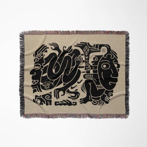 Pu&ograve; includere: Una coperta in tessuto intrecciato con sfondo beige e un design nero di figure stilizzate e forme geometriche.