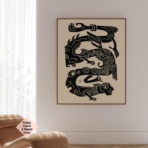 Op de afbeelding: Ingelijste kunstdruk met een zwart-beige ontwerp. Het kunstwerk toont gestileerde figuren en de woorden "MAYANDER GOING" in een uniek lettertype. De print wordt gepresenteerd in een bruine lijst.