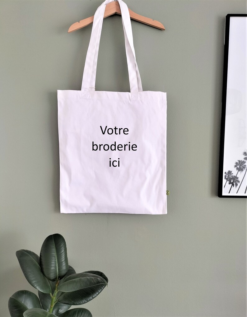 May include: White tote bag with the text "Votre broderie ici" printed in black.