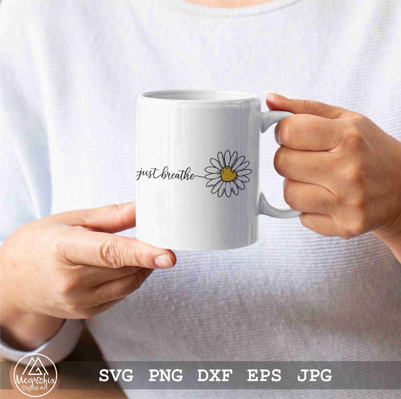 May include: White ceramic mug with a black outline of a daisy with a yellow centre and the text "just breathe" in black cursive.