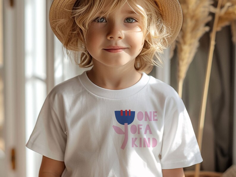 K&ouml;nnte beinhalten: Ein wei&szlig;es T-Shirt mit einer pinkfarbenen und blauen Grafik einer Blume und dem Text "ONE OF A KIND".