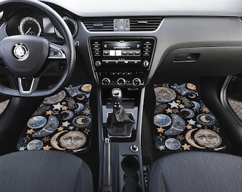 May include: Black car interior with custom floor mats featuring a celestial design with moons, stars, and faces.