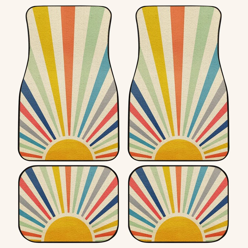 May include: Set of four car floor mats with a retro sunburst design. The mats feature a yellow sun with orange, red, blue, green, and gray rays on a beige background.