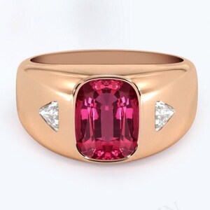 May include: A rose gold ring featuring a large, rectangular, pink gemstone flanked by two smaller, triangular, clear gemstones.