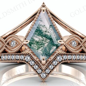 Puede incluir: Un anillo de compromiso de oro rosa con una piedra preciosa de ágata verde musgo y una banda de diamantes. El anillo tiene un diseño de inspiración vintage con detalles intrincados.