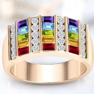 May include: A rose gold ring featuring a rainbow of colorful rectangular gemstones. The gemstones are arranged in a horizontal pattern, with a row of small, round, clear stones on either side. The ring has a smooth, polished finish.