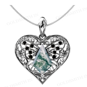 Puede incluir: Collar con colgante de plata en forma de corazón adornado con una piedra de ágata verde y blanca y detalles negros. El colgante presenta un delicado diseño de filigrana con un motivo de mariposa.