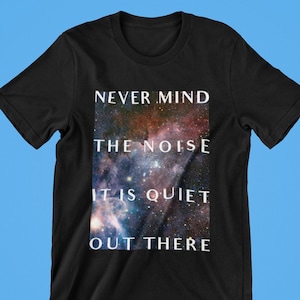 May include: Black t-shirt with a galaxy print and the text "NEVER MIND THE NOISE IT IS QUIET OUT THERE" in white.