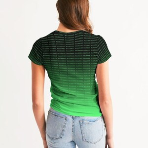 Op de afbeelding: Een zwart en groen T-shirt met een verloopontwerp met een herhalend patroon van binaire code. De code is groen op een zwarte achtergrond.