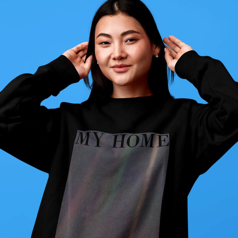 Puede incluir: Sudadera negra con un estampado gr&aacute;fico de una galaxia y el texto "MY HOME" en blanco.
