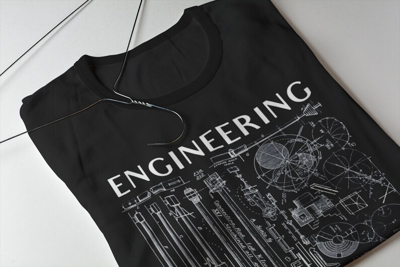 May include: Black t-shirt featuring a white print of the word "ENGINEERING" and a vintage style illustration of mechanical engineering designs.