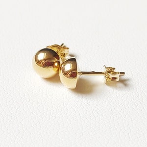 Pu&ograve; includere: Un paio di orecchini a lobo in oro con sfere. Gli orecchini sono semplici ed eleganti e sarebbero un ottimo regalo per ogni occasione.