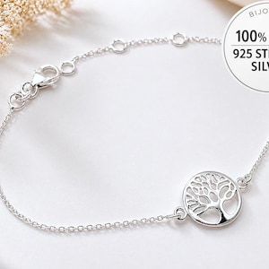 Puede incluir: Pulsera de plata de ley 925 con un colgante de árbol de la vida. La cadena fina tiene un cierre de mosquetón. El colgante calado representa un árbol estilizado. Una joya delicada y elegante.