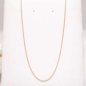 Puede incluir: Un delicado collar de cadena dorada exhibido sobre un fondo blanco. La cadena es fina y parece estar hecha de peque&ntilde;os eslabones interconectados. El collar es una pieza de joyer&iacute;a sencilla y elegante.