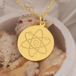 14K solid gold atom necklace featuring a dainty atomic design. Pendant size is 15 mm, with personalization options. Delivered in gift-ready packaging, ideal for science lovers, physicists, and chemistry enthusiasts.