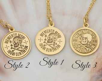 May include: Three gold necklaces with round pendants featuring a skull and crossbones design. The pendants have the text "Memento Mori" inscribed around the edge. The necklaces are labelled "Style 1", "Style 2", and "Style 3".
