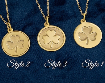 May include: Three gold-colored necklaces with circular pendants, each featuring a clover design. The pendants are suspended from delicate chains. The image includes the text "Style 2", "Style 3", and "Style 1". The background is a dark blue fabric.