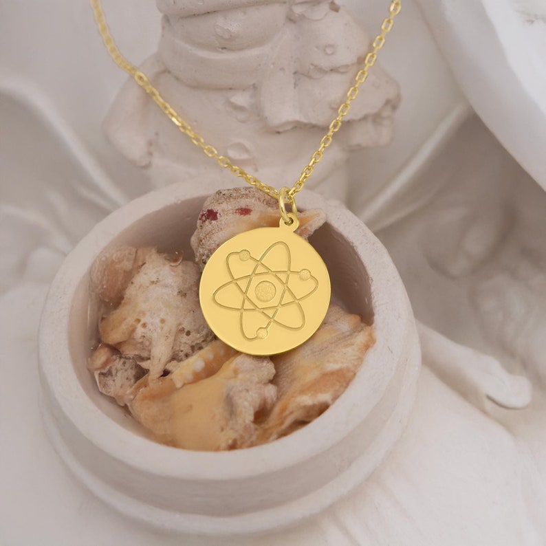 14K solid gold atom necklace featuring a dainty atomic design. Pendant size is 15 mm, with personalization options. Delivered in gift-ready packaging, ideal for science lovers, physicists, and chemistry enthusiasts.