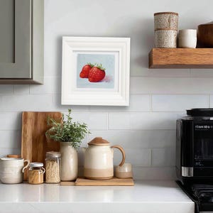 Strawberry painting. Original oil painting on cardboard of two red strawberries on a light blue background.
