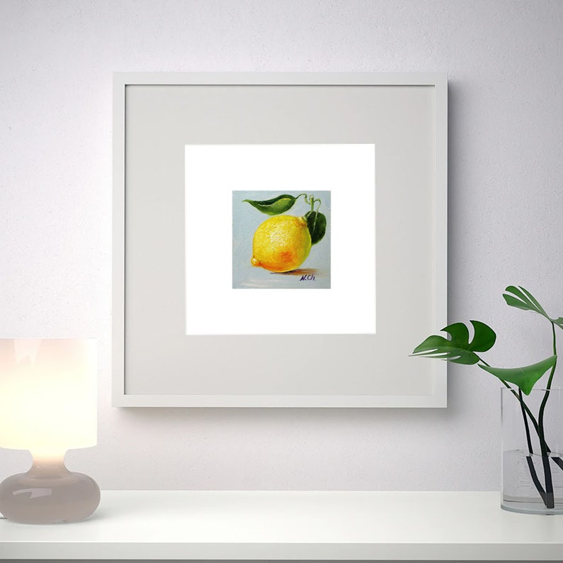Lemon oil painting. A painting of a single yellow lemon with green leaves on a light blue background. The painting is signed in the bottom right corner.