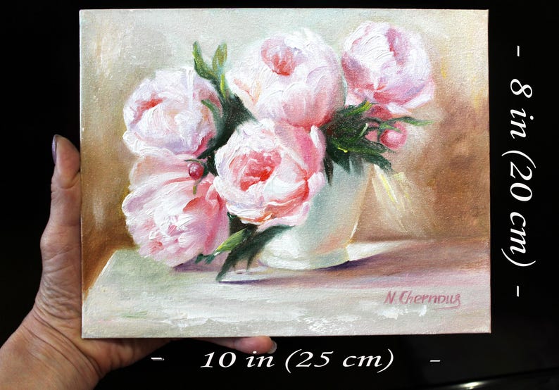 Peonies oil painting of a bouquet of pink peonies in a white vase. The flowers have multiple layers of petals and green leaves. The background is a soft, neutral color, and the painting is signed in the bottom right corner.