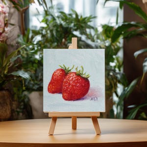 Strawberry painting. Original oil painting on cardboard of two red strawberries on a light blue background.