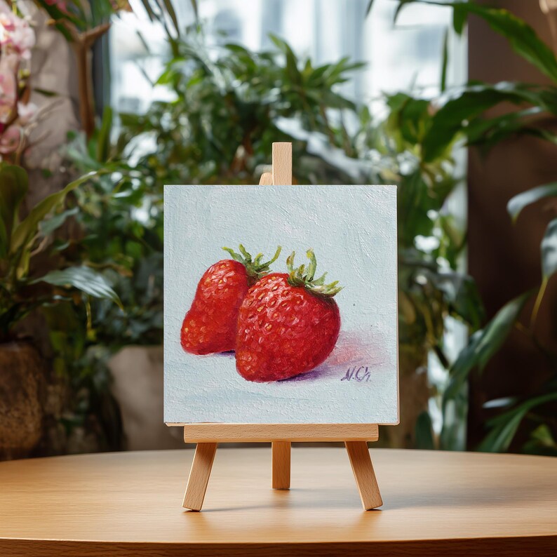 Strawberry painting. Original oil painting on cardboard of two red strawberries on a light blue background.