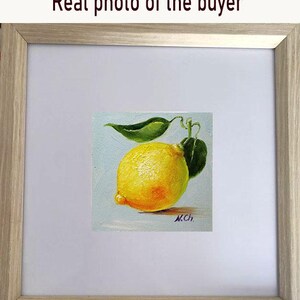 Lemon oil painting. A yellow lemon with a green leaf, painted in oil on a light blue background. The artist's signature, "N.Ch.", is in the lower right corner.