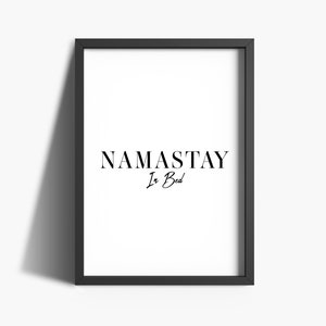 May include: Black and white framed print with the text "NAMASTAY In Bed" in a modern font.
