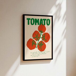 May include: A framed poster with the word "TOMATO" in green letters and a drawing of red tomatoes on a vine. The text below the tomatoes reads "Your soy tomato. We've perfected it. Eat all the whole thing and explore the delicious ways to eat this unexpected fruit."
