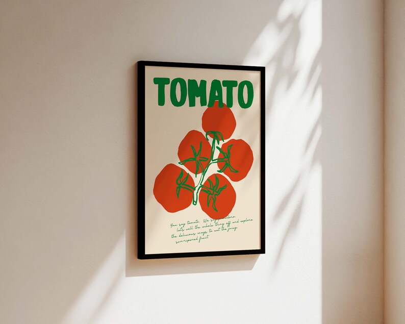 May include: A framed poster with the word "TOMATO" in green letters and a drawing of red tomatoes on a vine. The text below the tomatoes reads "Your soy tomato. We've perfected it. Eat all the whole thing and explore the delicious ways to eat this unexpected fruit."