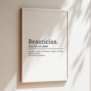 May include: A white framed print with the word "Beautician" in black text, defined as "an artist, crafter of perfection, sculptor of lashes, shaper of brows. also a low-key therapist."