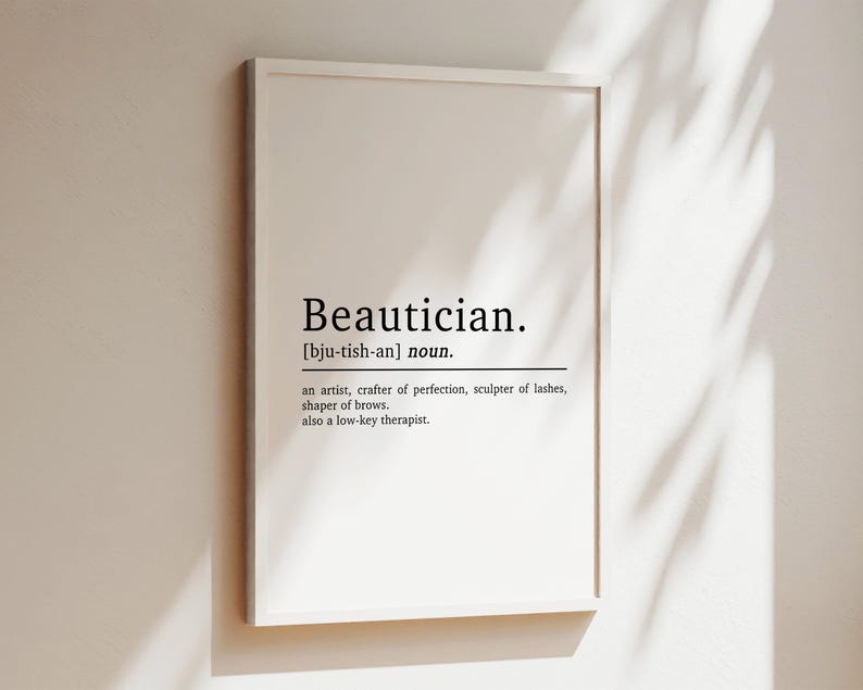 May include: A white framed print with the word "Beautician" in black text, defined as "an artist, crafter of perfection, sculptor of lashes, shaper of brows. also a low-key therapist."