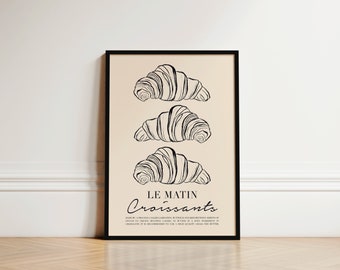 May include: A black and white illustration of three croissants on a beige background. The text "Le Matin Croissants" is below the croissants. The text reads "Made by a process called laminating, butter is stacked between sheets of dough, then folded and rolled to create multiple layers.  A key ingredient in croissants is it is recommended to use a high quality grass fed butter."