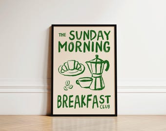 May include: A framed print with a green and white design. The text reads "The Sunday Morning Breakfast Club". The design includes a coffee pot, a cup of coffee, a croissant, and coffee beans.