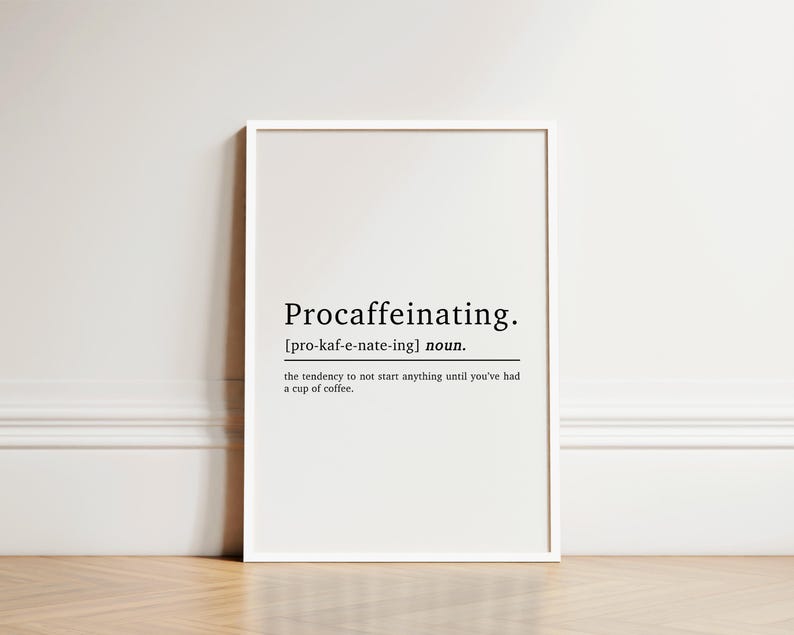 May include: A white framed print with the word "Procaffeinating" defined as "the tendency to not start anything until you've had a cup of coffee."